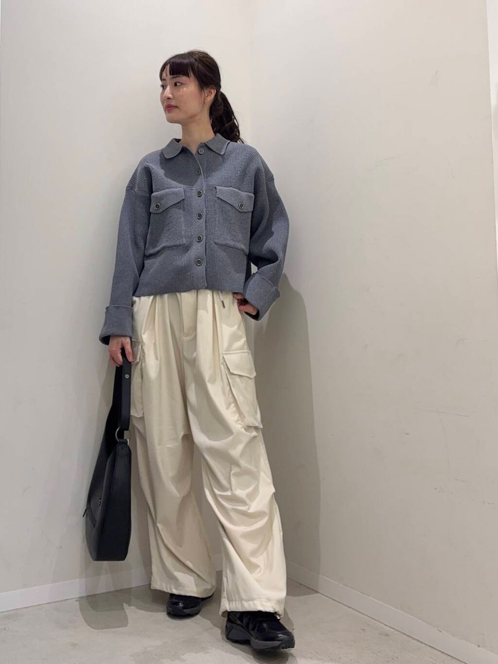 ブラック系のショルダーバッグ、ブルー系のその他アウター、ブラック系のスニーカーを着用したレディースの春コーディネートの3枚目の写真