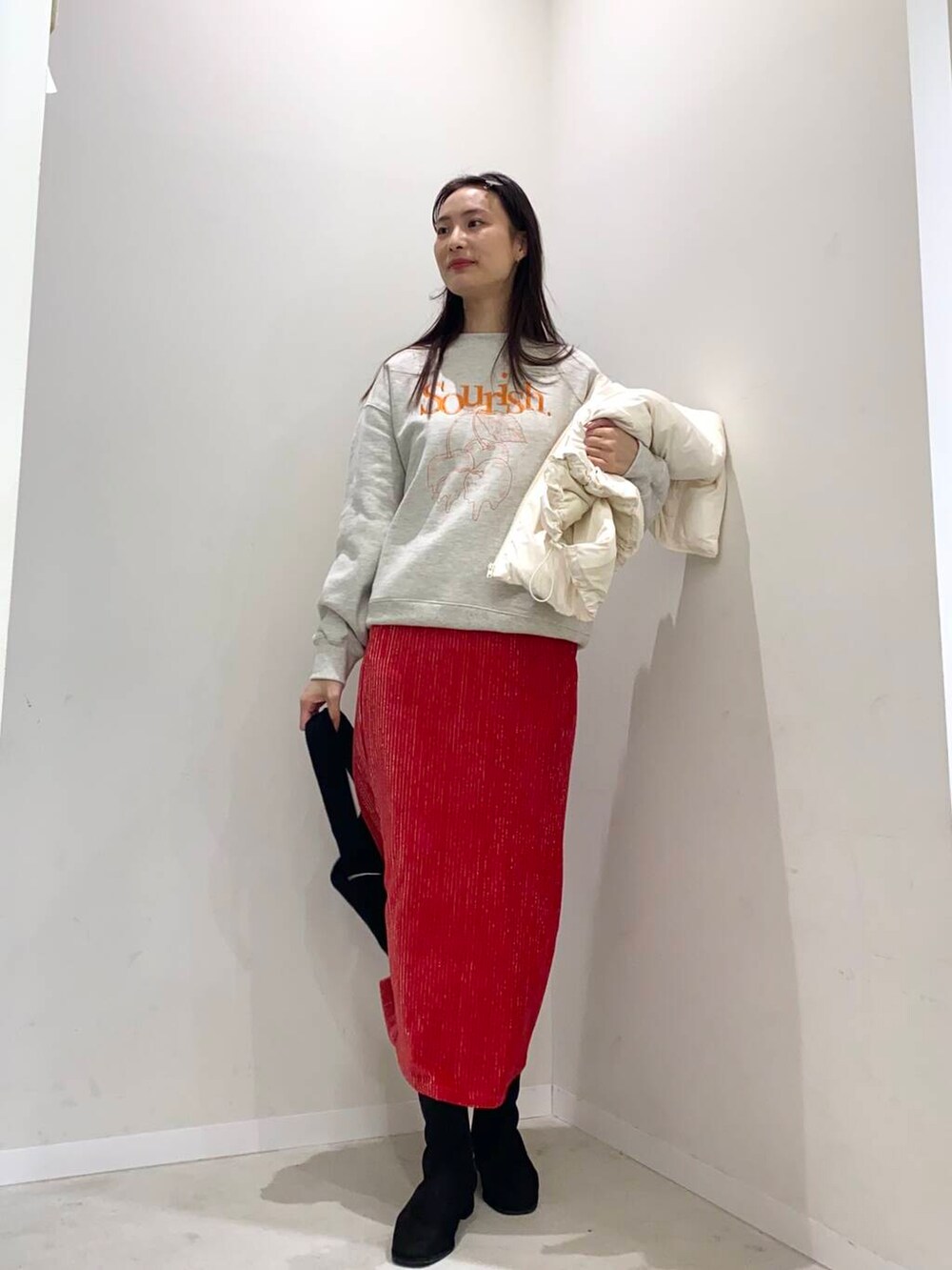 ブラック系のブーツ、ホワイト系のダウンベスト、その他のスウェットを着用したレディースの秋コーディネートの3枚目の写真