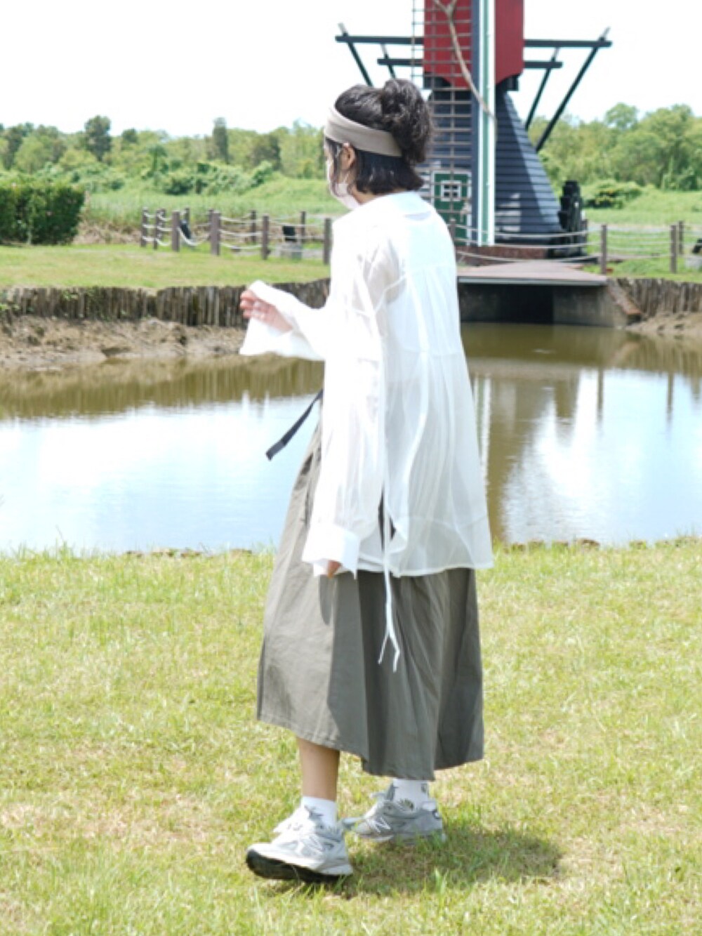グレー系のスニーカー、その他のスカート、ホワイト系のポンチョを着用したレディースの夏コーディネートの3枚目の写真
