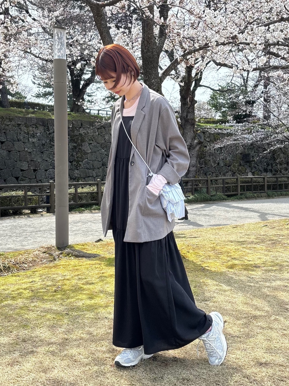 グレー系のテーラードジャケット、ピンク系のTシャツ/カットソー、ホワイト系のスニーカーを着用したレディースの春コーディネートの3枚目の写真