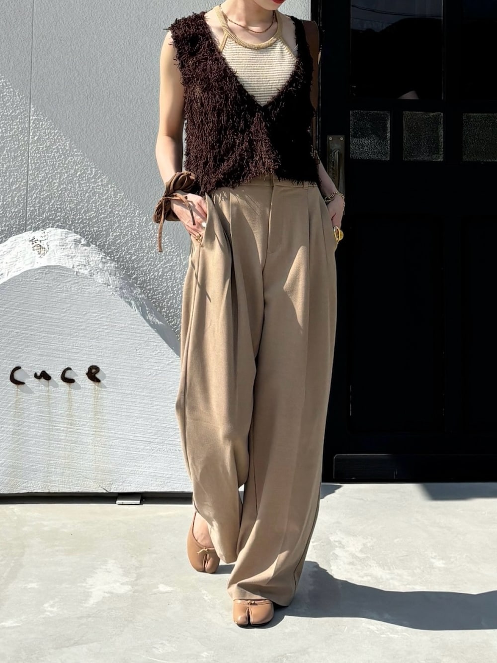 ブラウン系のベスト、ベージュ系のトップスを着用したレディースの秋コーディネートの2枚目の写真