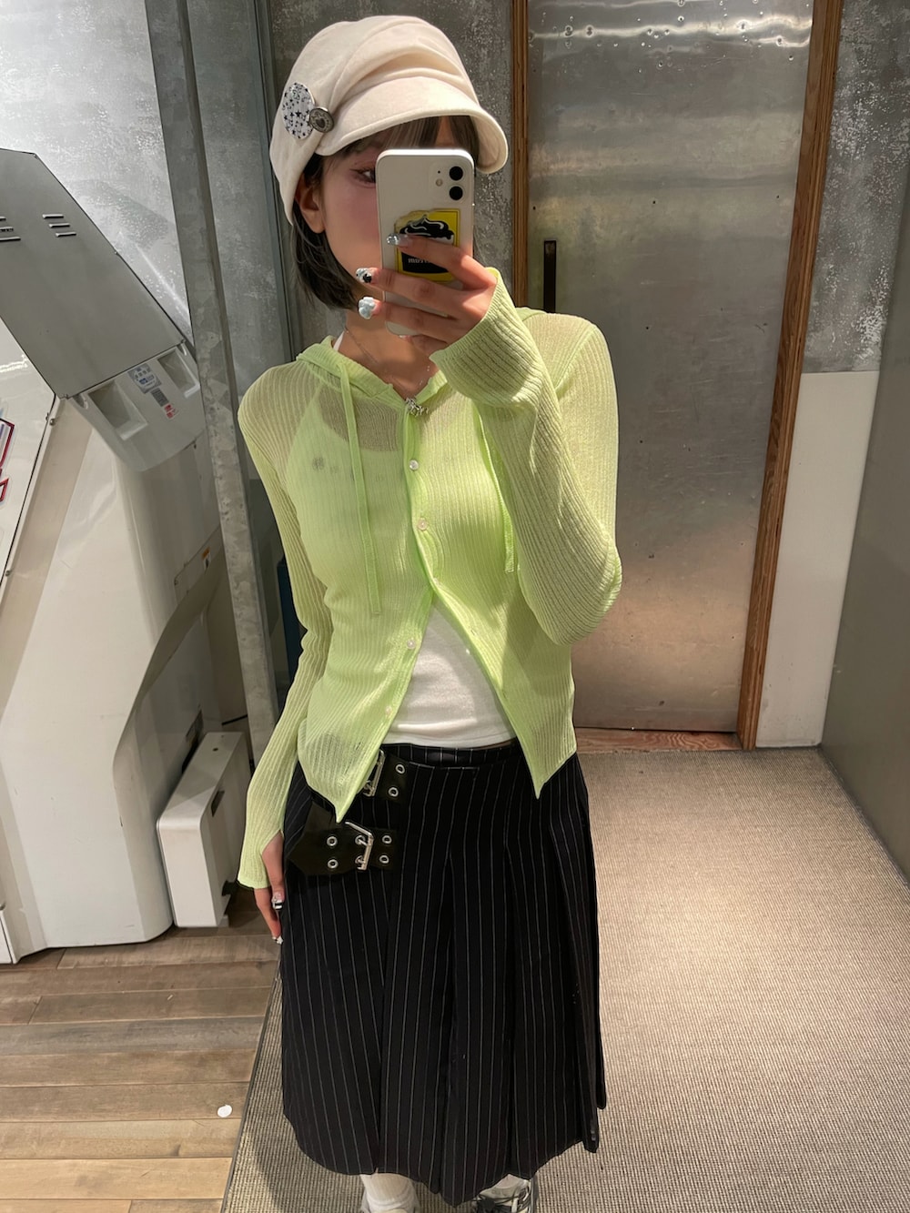 イエロー系のカーディガン/ボレロ、ホワイト系のキャミソール、ブルー系のスカートを着用したレディースの春コーディネートの2枚目の写真