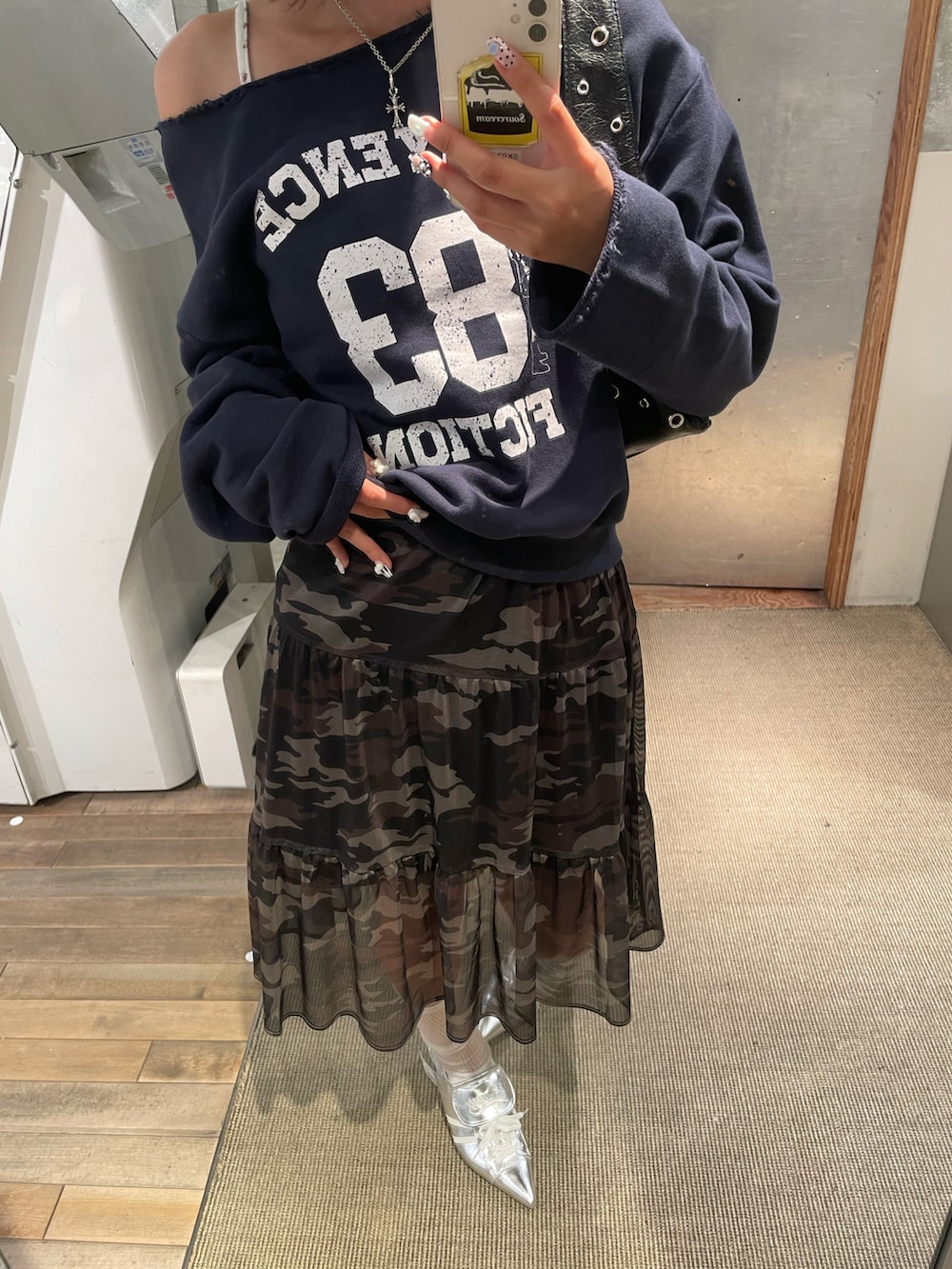 ブルー系のスウェット、ブラック系のショルダーバッグ、グリーン系のスカートを着用したレディースの秋コーディネートの3枚目の写真