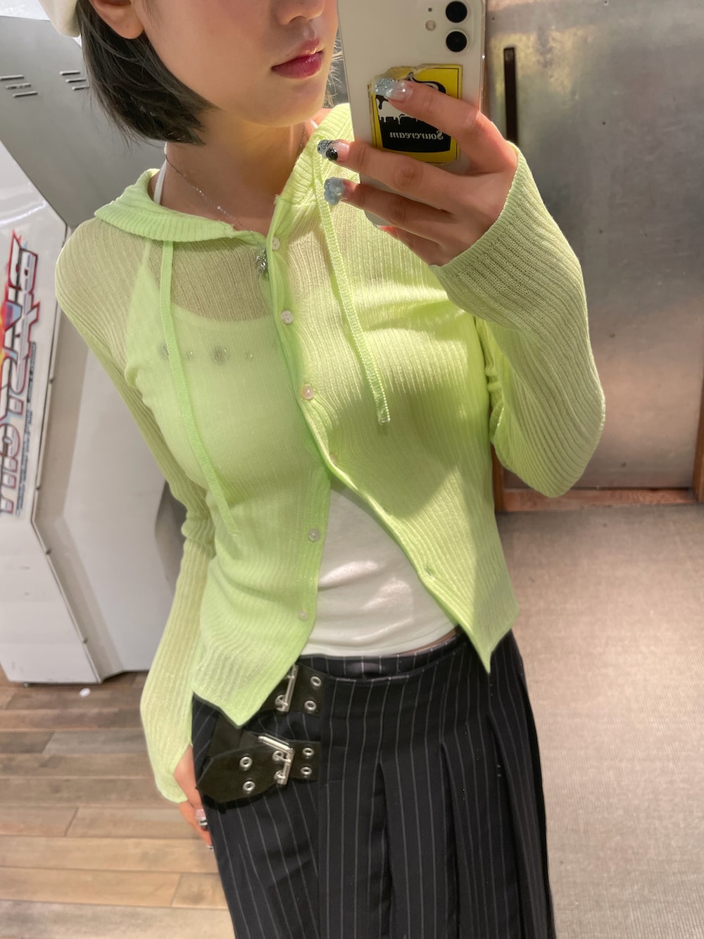 イエロー系のカーディガン/ボレロ、ホワイト系のキャミソール、ブルー系のスカートを着用したレディースの春コーディネートの3枚目の写真