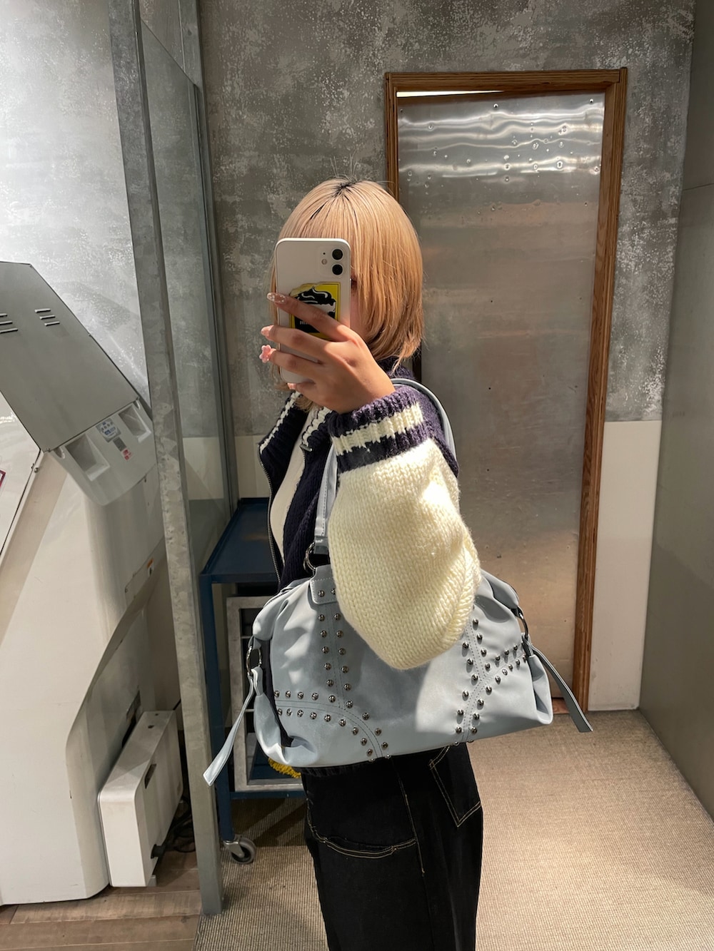 ホワイト系のニット/セーター、ブルー系のトップス、ブルー系のデニムパンツを着用したレディースの冬コーディネートの2枚目の写真