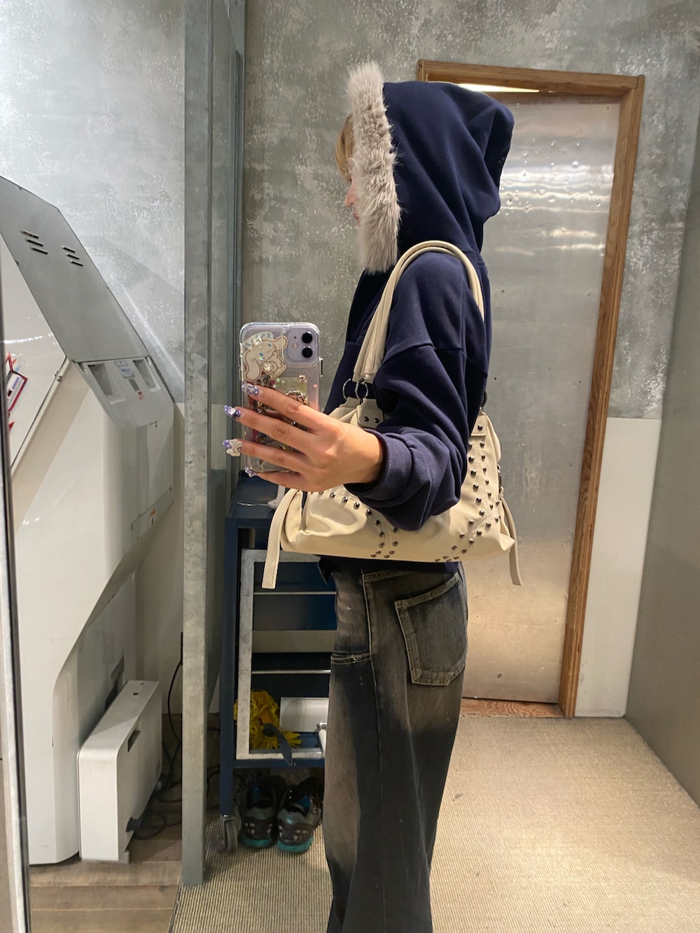 ブルー系のパーカー、ブルー系のニット/セーター、ブルー系のデニムパンツを着用したレディースの冬コーディネートの3枚目の写真