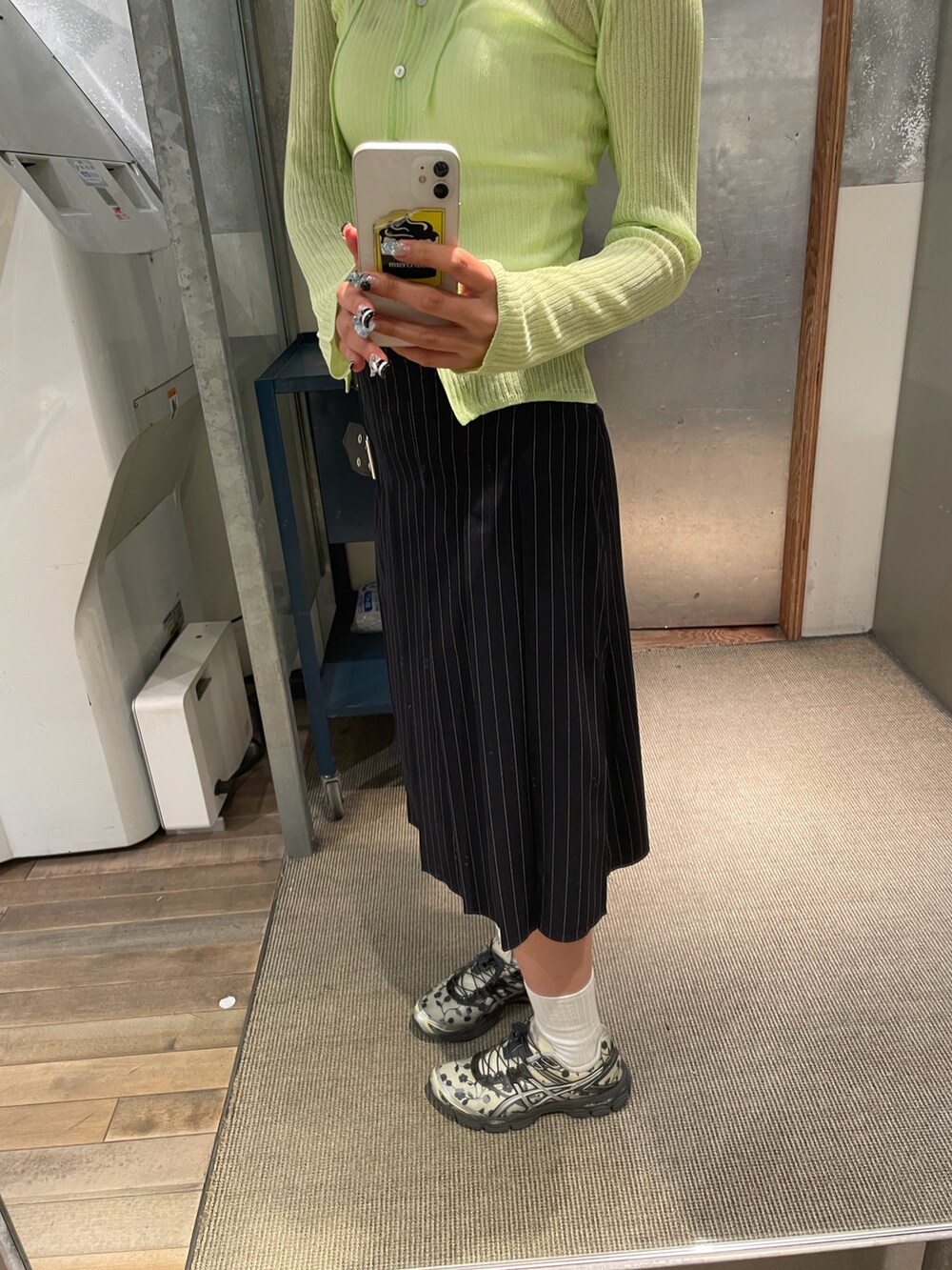 イエロー系のカーディガン/ボレロ、ホワイト系のキャミソール、ブルー系のスカートを着用したレディースの春コーディネートの4枚目の写真