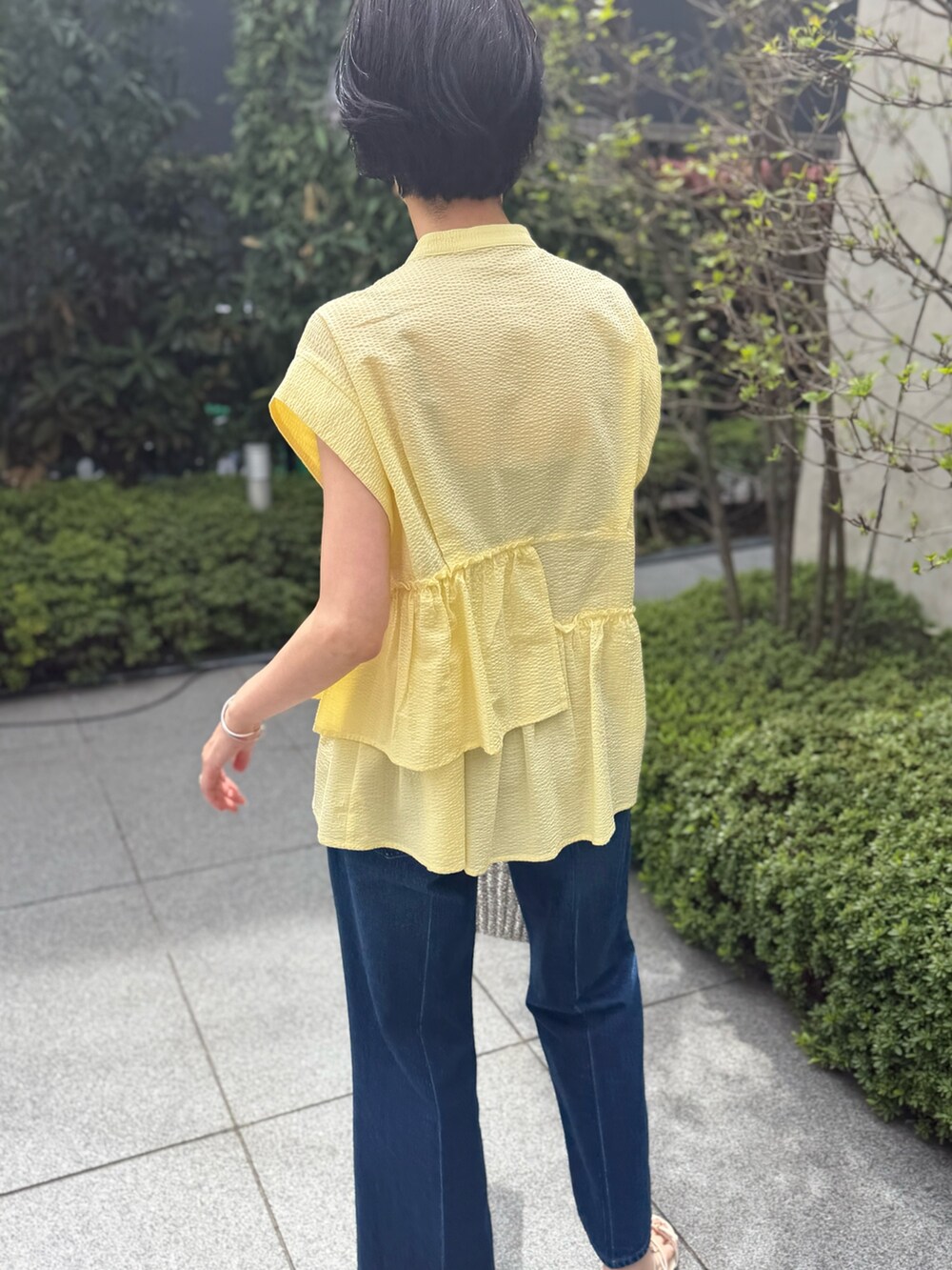 ブルー系のデニムパンツ、イエロー系のシャツ/ブラウス、ブルー系のストール/ショールを着用したレディースの春コーディネートの2枚目の写真
