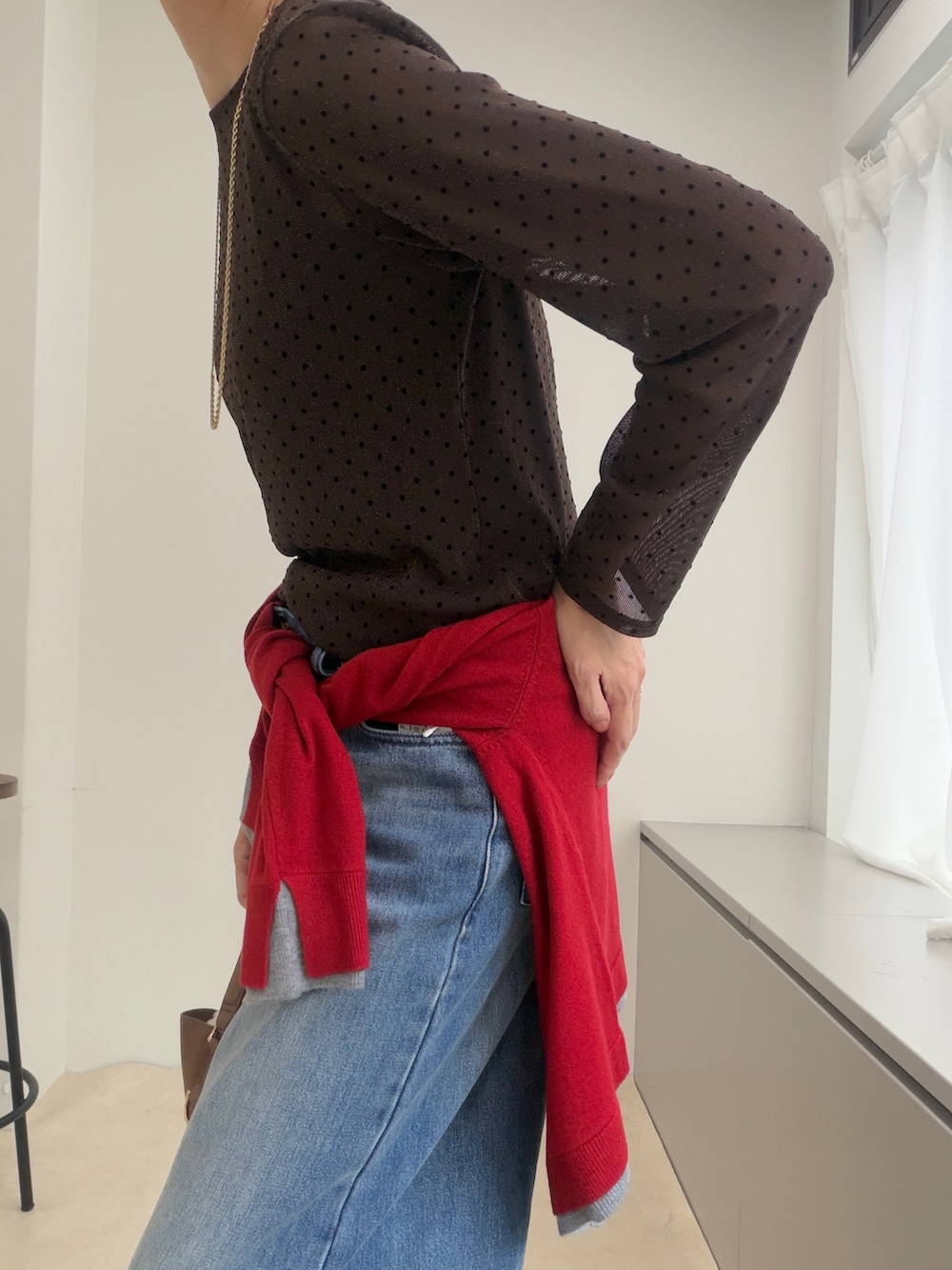ブラウン系のTシャツ/カットソー、レッド系のカーディガン/ボレロ、ゴールド系のイヤリングを着用したレディースの秋コーディネートの3枚目の写真