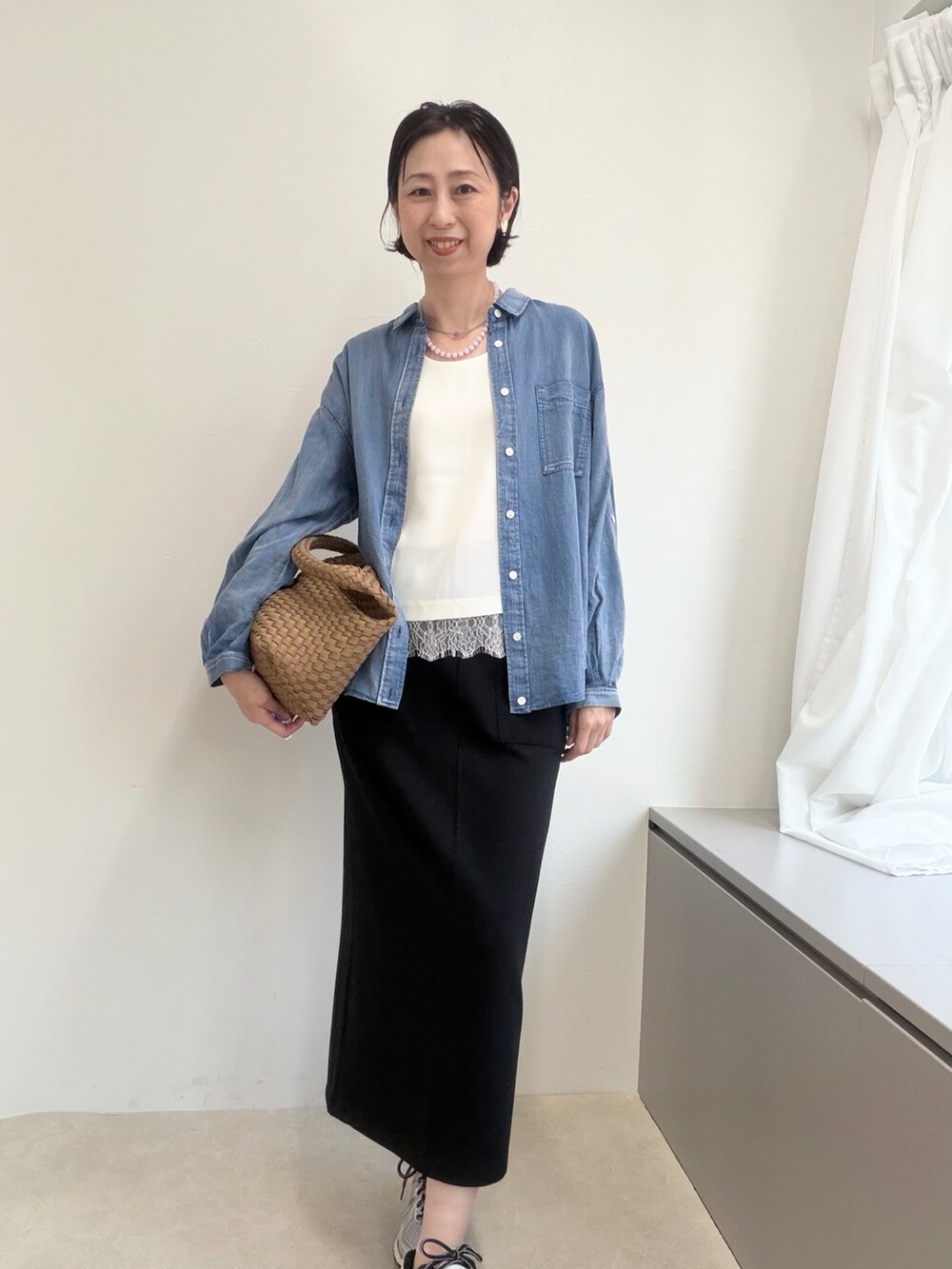 ブラック系のスカート、グレー系のシャツ/ブラウス、ブラウン系のショルダーバッグを着用したレディースの春コーディネートの2枚目の写真