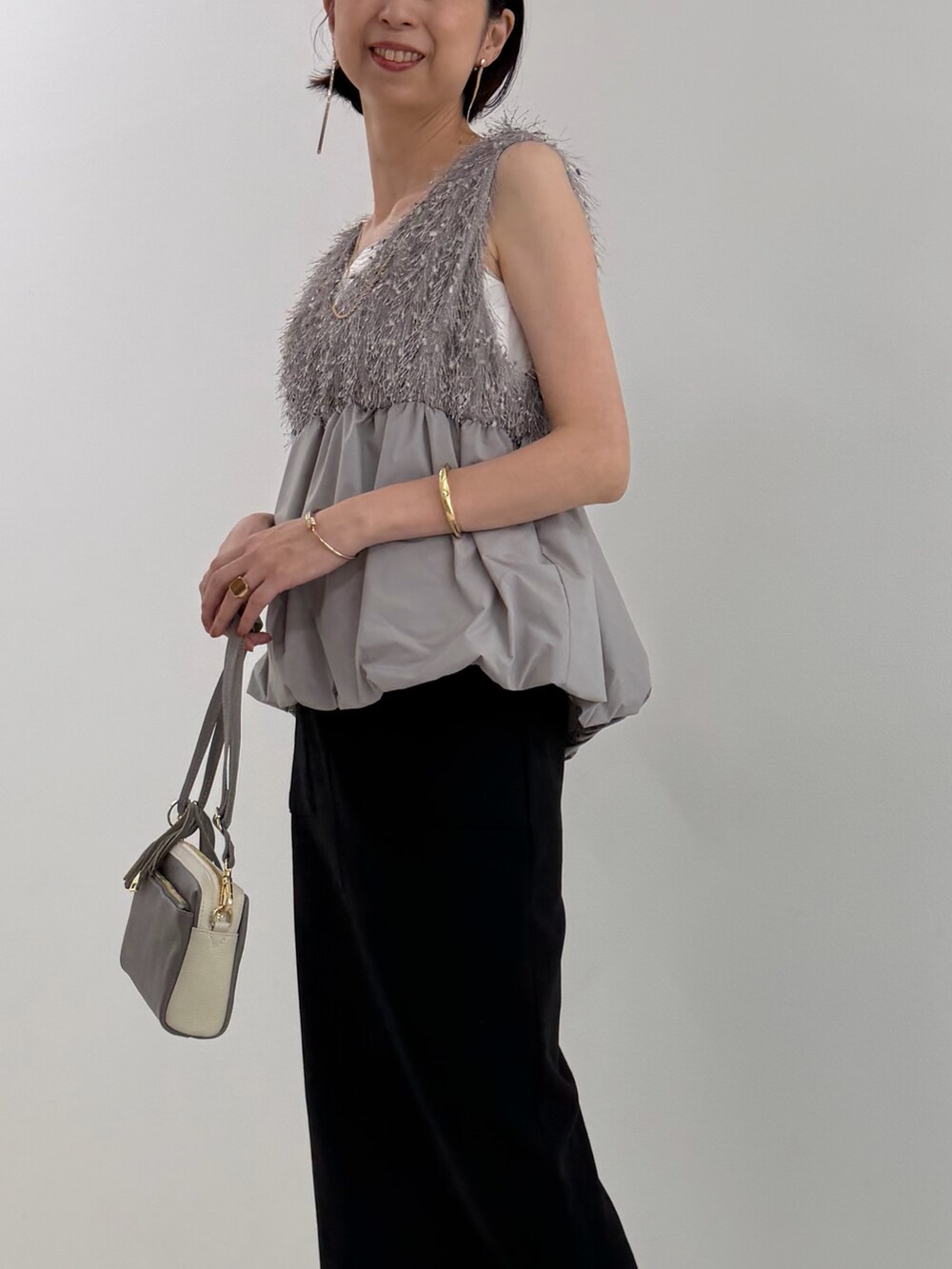 ブラック系のスカート、グレー系のシャツ/ブラウス、ホワイト系のTシャツ/カットソーを着用したレディースの春コーディネートの5枚目の写真