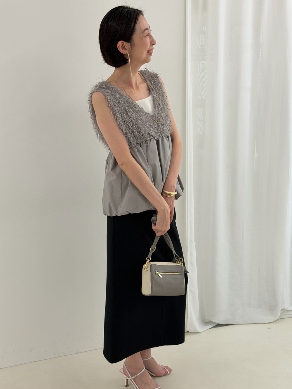 ブラック系のスカート、グレー系のシャツ/ブラウス、ホワイト系のTシャツ/カットソーを着用したレディースの春コーディネートの10枚目の写真