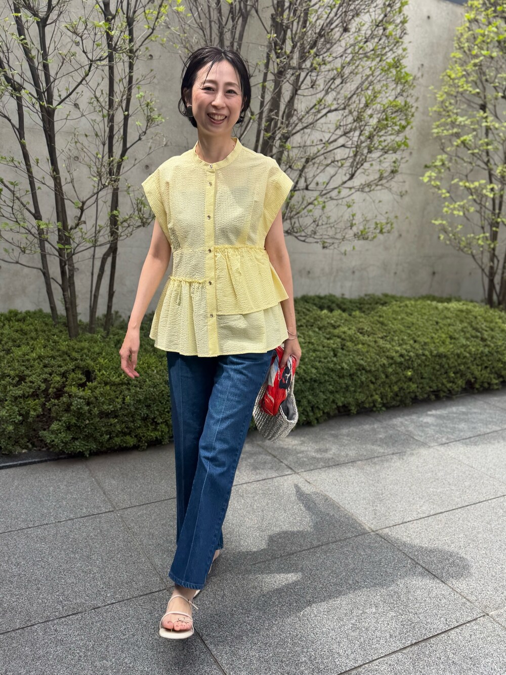 ブルー系のデニムパンツ、イエロー系のシャツ/ブラウス、ブルー系のストール/ショールを着用したレディースの春コーディネートの9枚目の写真
