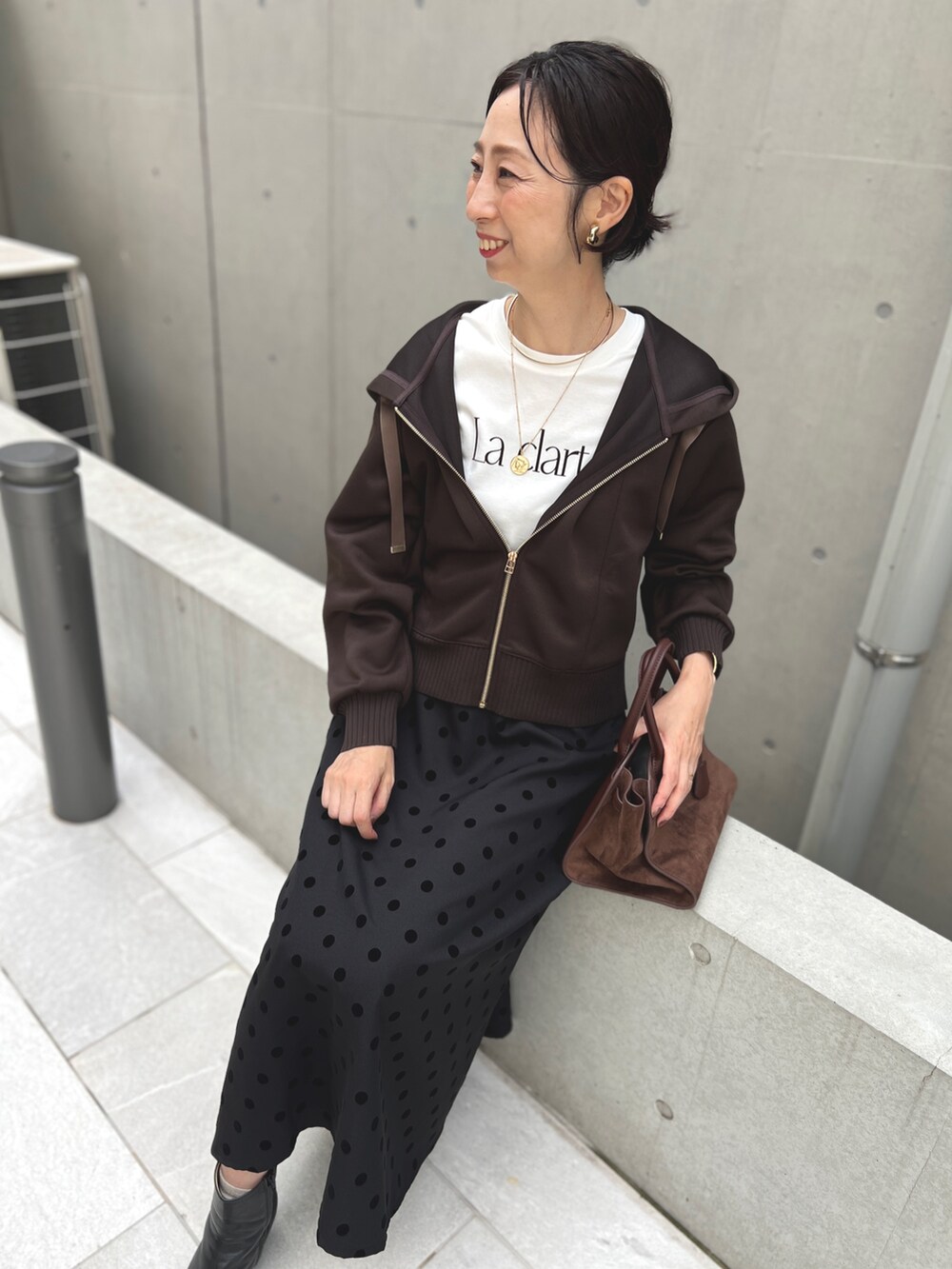 ブラウン系のスカート、ブラウン系のパーカーを着用したレディースの秋コーディネートの2枚目の写真