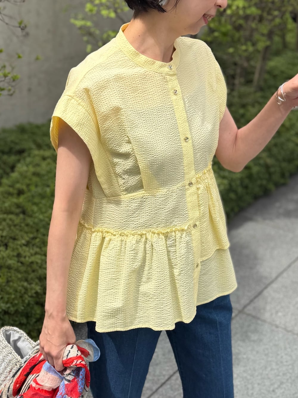 ブルー系のデニムパンツ、イエロー系のシャツ/ブラウス、ブルー系のストール/ショールを着用したレディースの春コーディネートの6枚目の写真