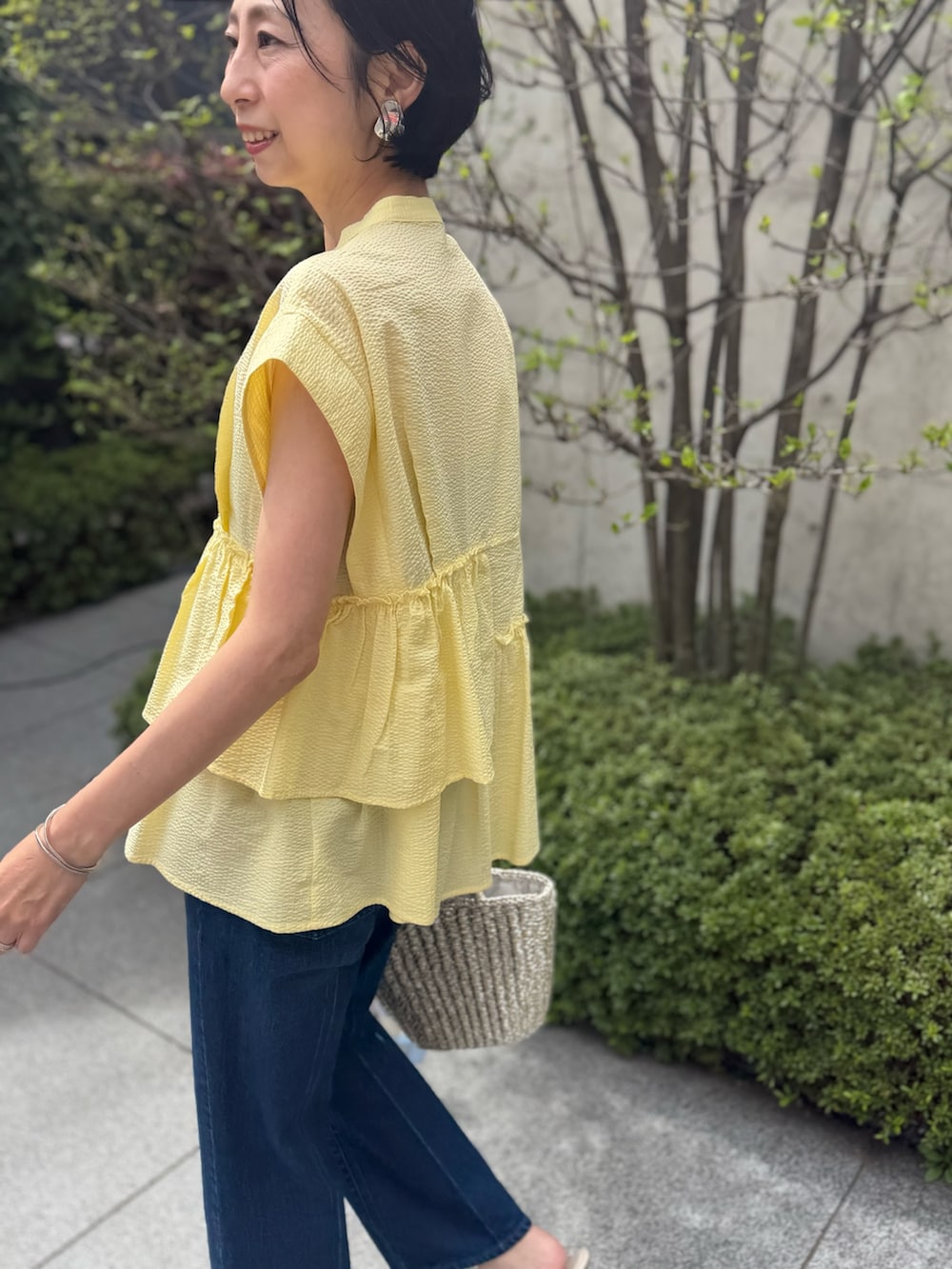 ブルー系のデニムパンツ、イエロー系のシャツ/ブラウス、ブルー系のストール/ショールを着用したレディースの春コーディネートの3枚目の写真