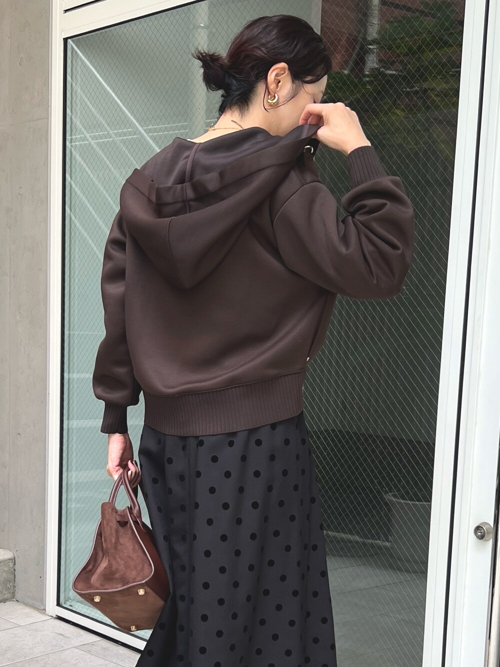 ブラウン系のスカート、ブラウン系のパーカーを着用したレディースの秋コーディネートの5枚目の写真