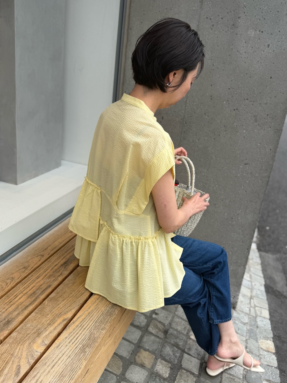 ブルー系のデニムパンツ、イエロー系のシャツ/ブラウス、ブルー系のストール/ショールを着用したレディースの春コーディネートの5枚目の写真