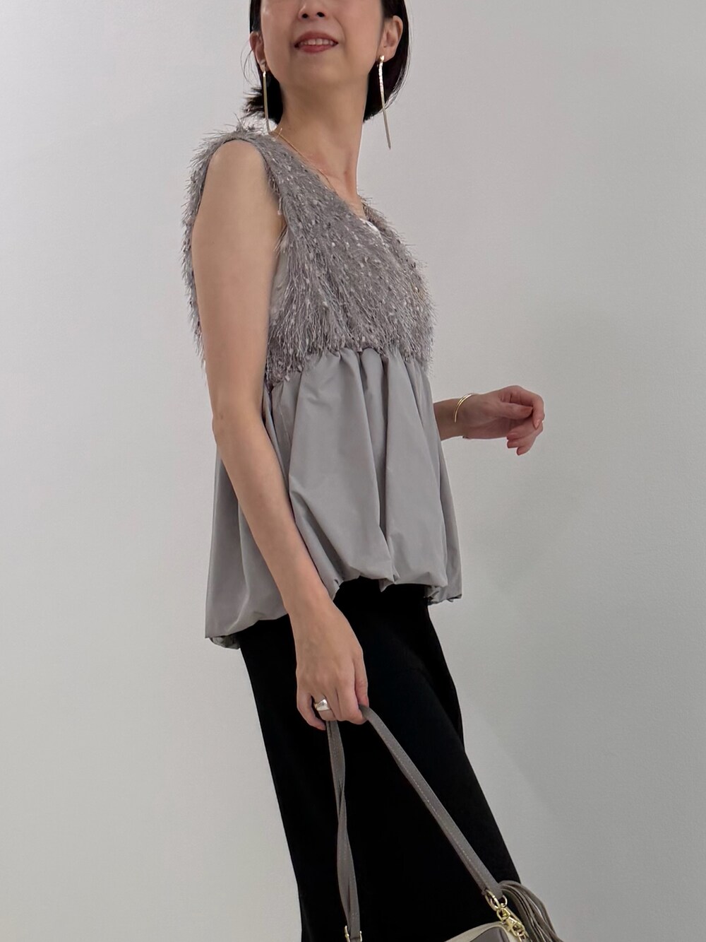 ブラック系のスカート、グレー系のシャツ/ブラウス、ホワイト系のTシャツ/カットソーを着用したレディースの春コーディネートの3枚目の写真