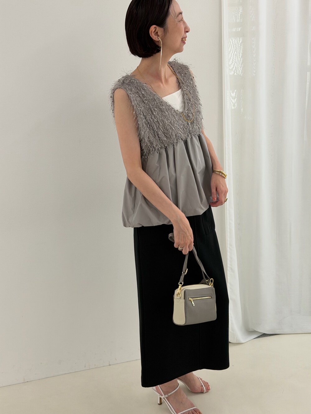 ブラック系のスカート、グレー系のシャツ/ブラウス、ホワイト系のTシャツ/カットソーを着用したレディースの春コーディネートの9枚目の写真