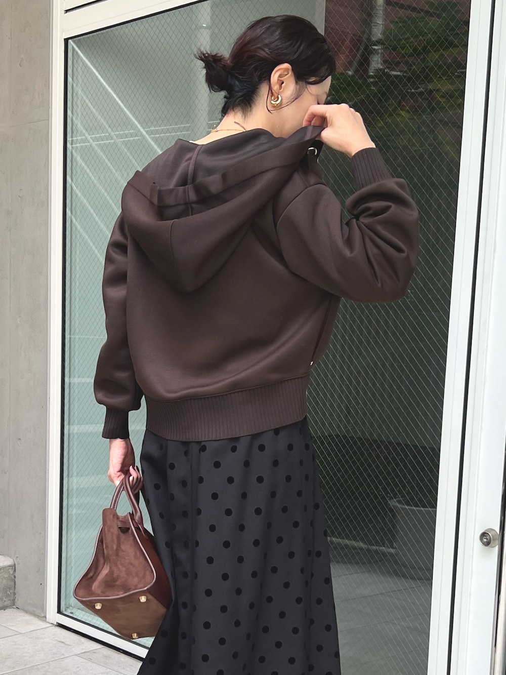 ブラウン系のスカート、ブラウン系のパーカーを着用したレディースの秋コーディネートの4枚目の写真