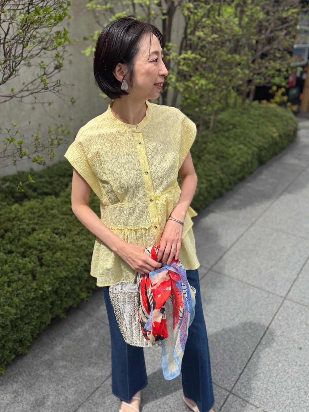 ブルー系のデニムパンツ、イエロー系のシャツ/ブラウス、ブルー系のストール/ショールを着用したレディースの春コーディネートの7枚目の写真