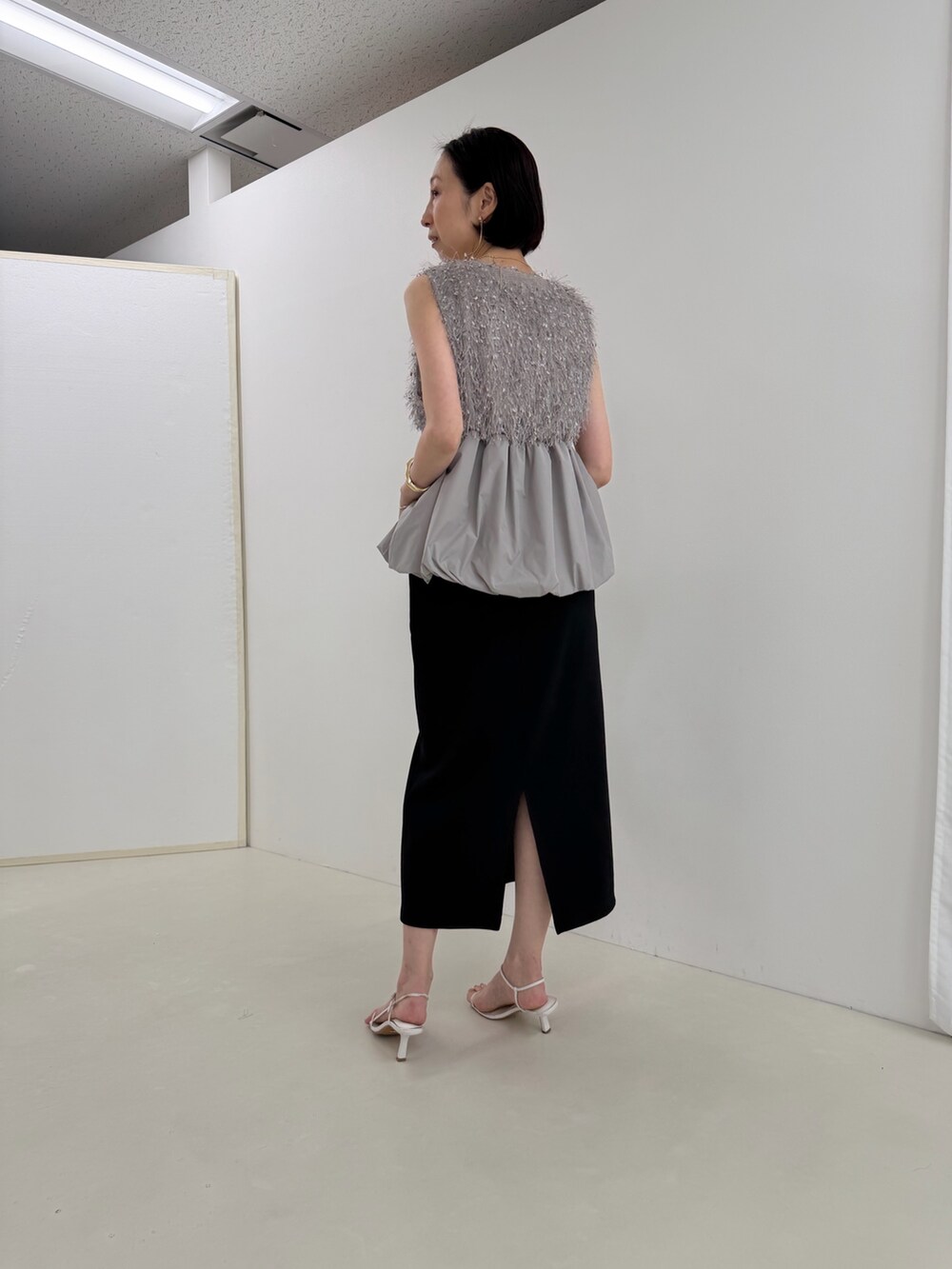 ブラック系のスカート、グレー系のシャツ/ブラウス、ホワイト系のTシャツ/カットソーを着用したレディースの春コーディネートの6枚目の写真