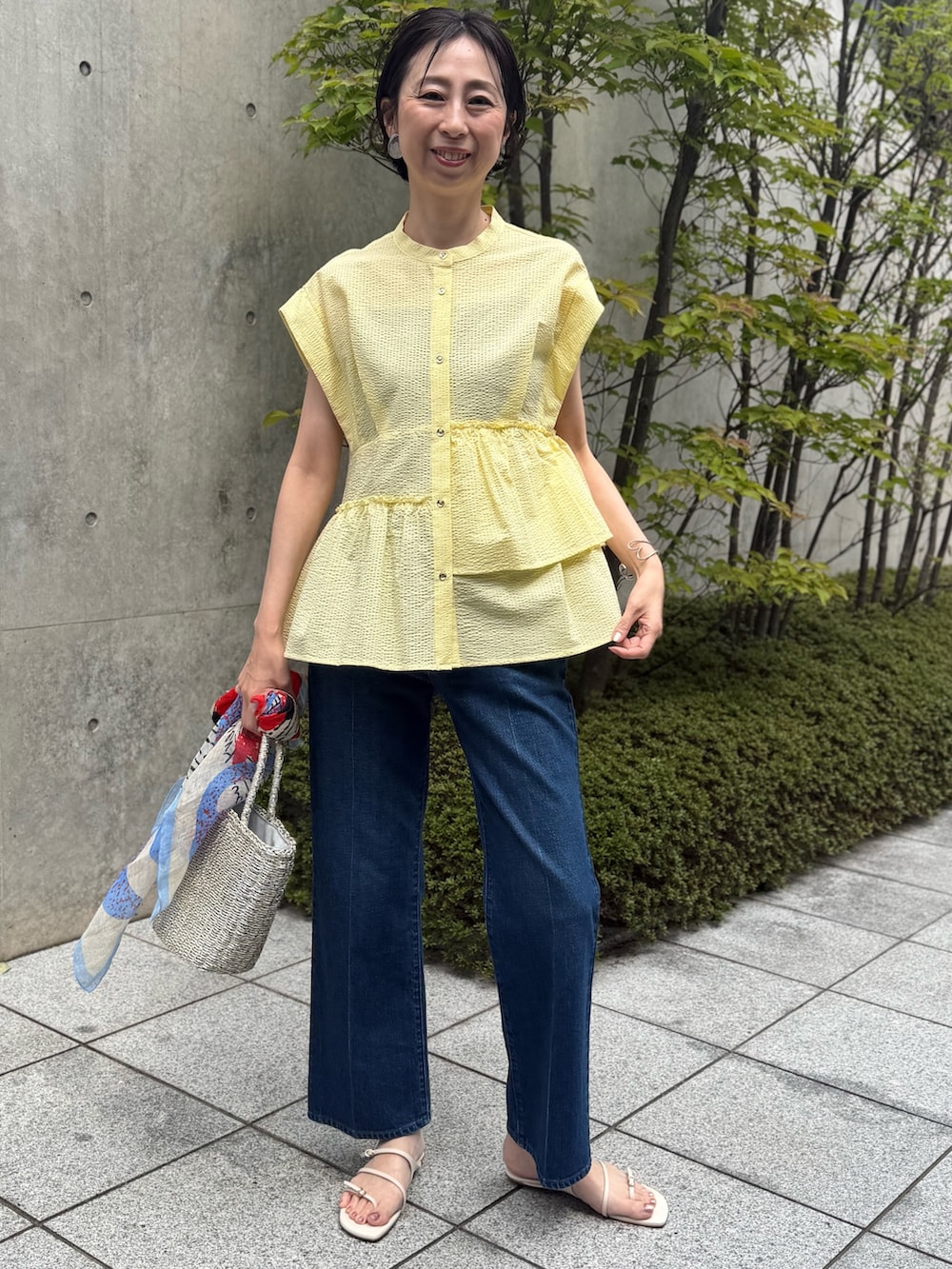 ブルー系のデニムパンツ、イエロー系のシャツ/ブラウス、ブルー系のストール/ショールを着用したレディースの春コーディネートの10枚目の写真
