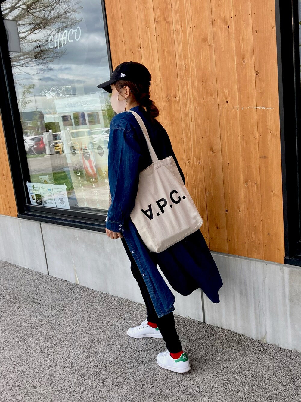 ブラック系のパンツ、ホワイト系のスニーカー、ブラウン系のベストを着用したレディースの春コーディネートの3枚目の写真