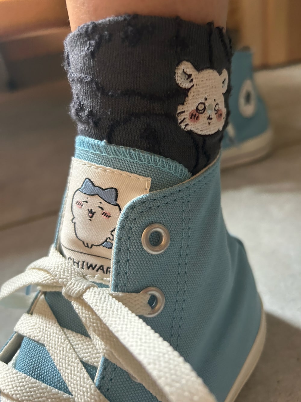 ブルー系のデニムパンツ、ブラック系のパーカー、ブルー系のスニーカーを着用したレディースの夏コーディネートの2枚目の写真