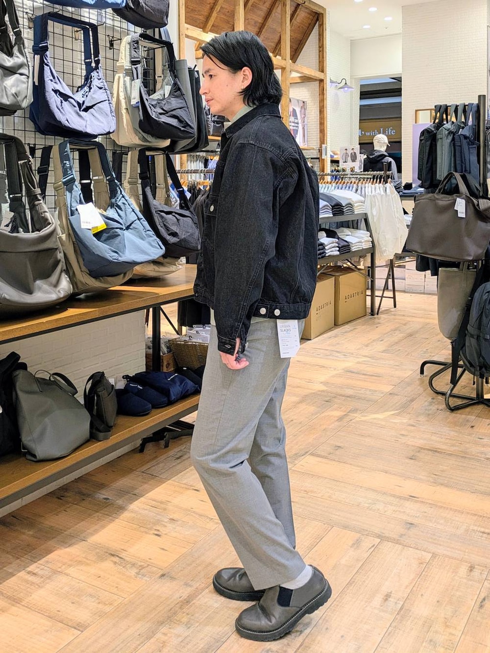 グレー系のその他シューズ、ブラック系のデニムジャケット、グレー系のスラックスを着用したメンズの春コーディネートの2枚目の写真