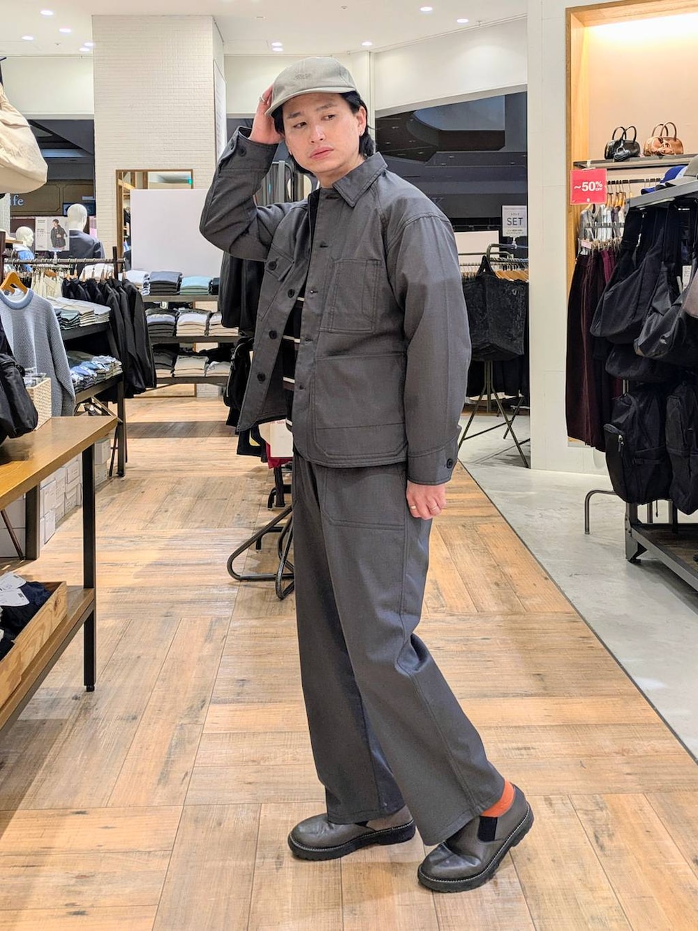 グレー系のブルゾン、グレー系のデニムパンツ、ベージュ系のキャップを着用したメンズの冬コーディネートの2枚目の写真