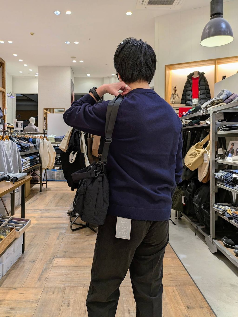 ブルー系のニット/セーター、ブラウン系のその他パンツ、ブラック系のショルダーバッグを着用したメンズの秋コーディネートの3枚目の写真
