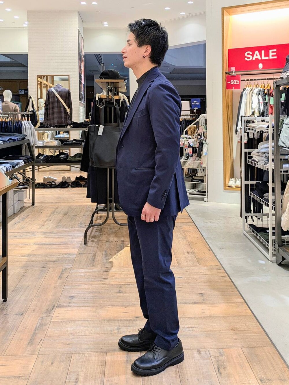 ブルー系のテーラードジャケット、ブルー系のスラックス、グレー系のニット/セーターを着用したメンズの秋コーディネートの2枚目の写真