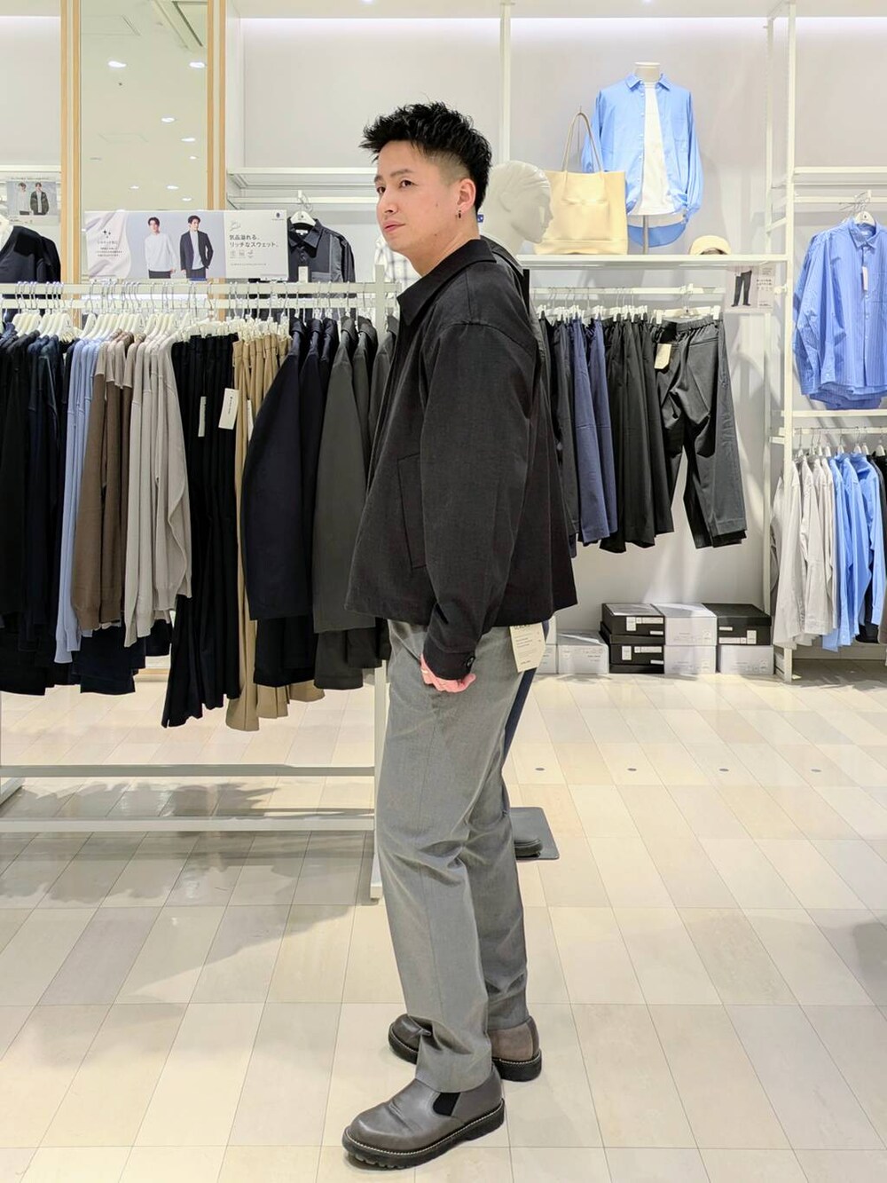 ブルー系のブルゾン、ホワイト系のニット/セーター、グレー系のスラックスを着用したメンズの春コーディネートの2枚目の写真