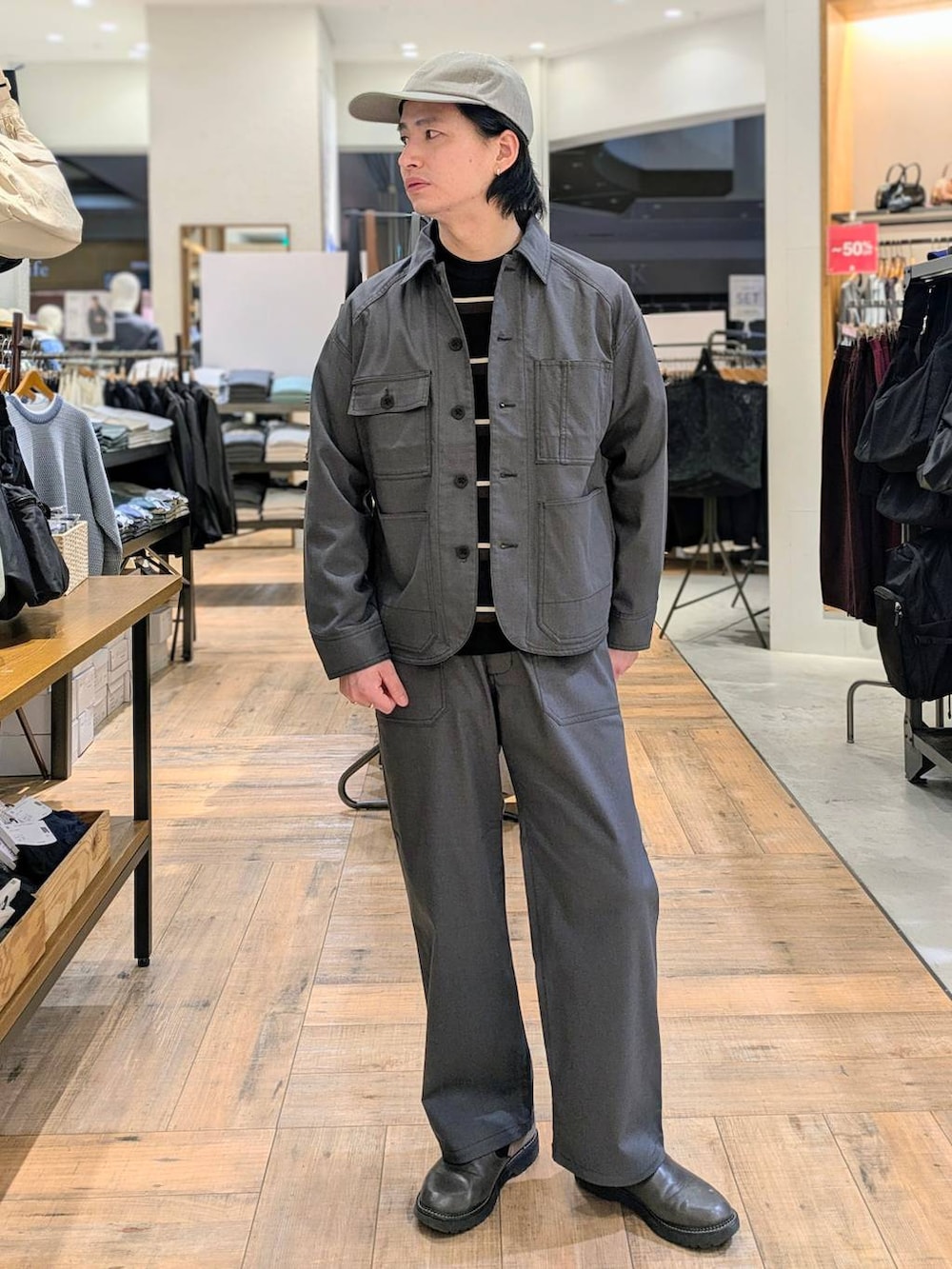 グレー系のブルゾン、グレー系のデニムパンツ、ベージュ系のキャップを着用したメンズの冬コーディネートの3枚目の写真