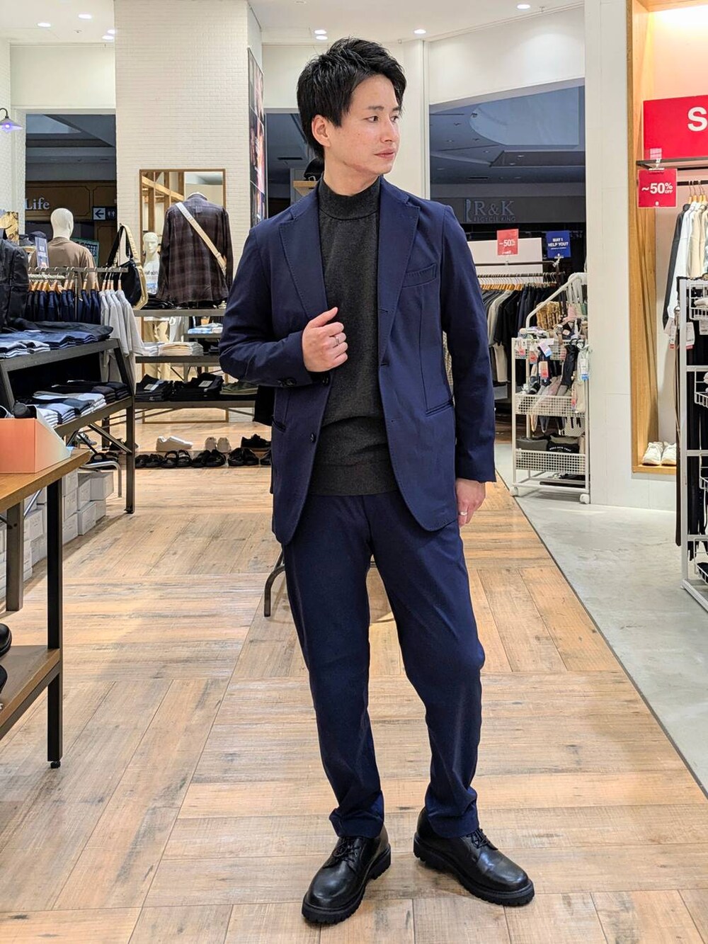 ブルー系のテーラードジャケット、ブルー系のスラックス、グレー系のニット/セーターを着用したメンズの秋コーディネートの4枚目の写真