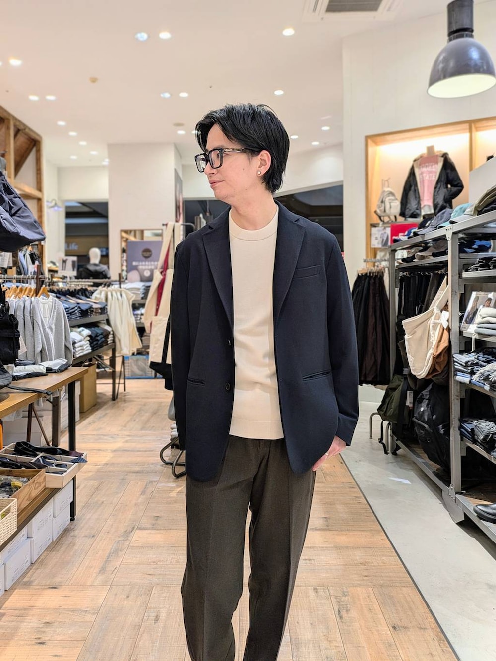 ホワイト系のニット/セーター、ブラウン系のスラックス、ブルー系のテーラードジャケットを着用したメンズの冬コーディネートの3枚目の写真