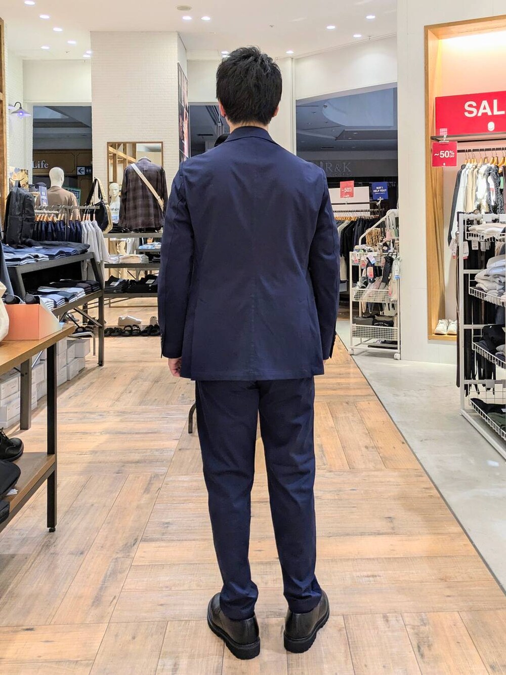 ブルー系のテーラードジャケット、ブルー系のスラックス、グレー系のニット/セーターを着用したメンズの秋コーディネートの3枚目の写真