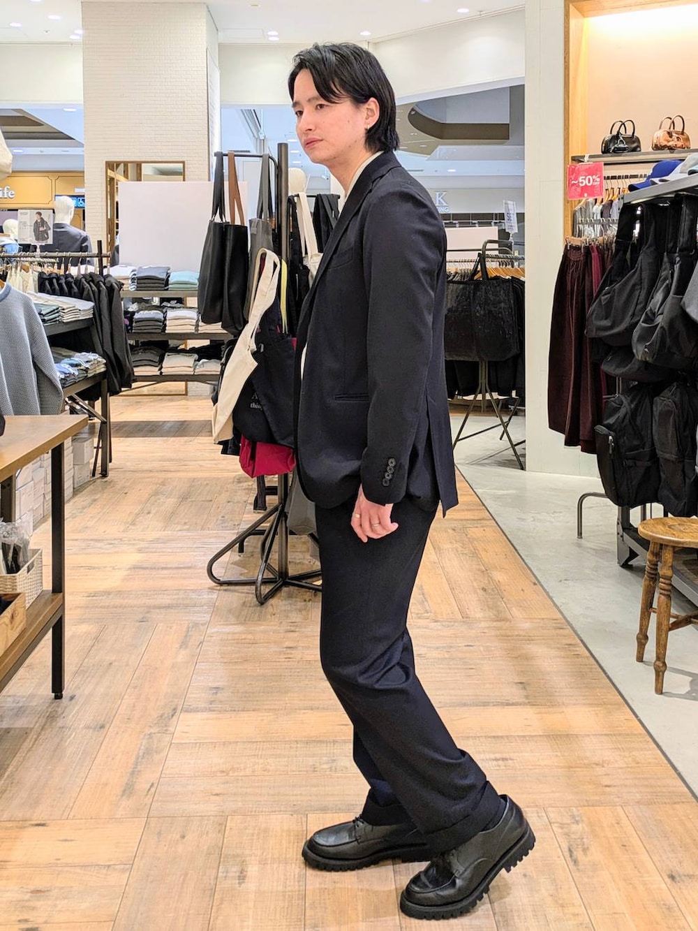 ブラック系のその他シューズ、ブルー系のテーラードジャケット、ブルー系のスラックスを着用したメンズの冬コーディネートの2枚目の写真