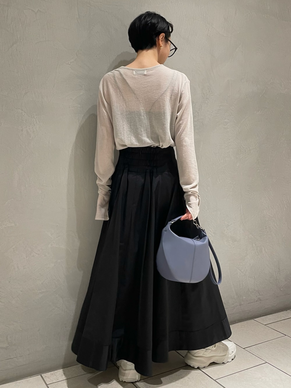 ブラック系のキャミソール、グレー系のTシャツ/カットソー、ブラック系のスカートを着用したレディースの冬コーディネートの2枚目の写真