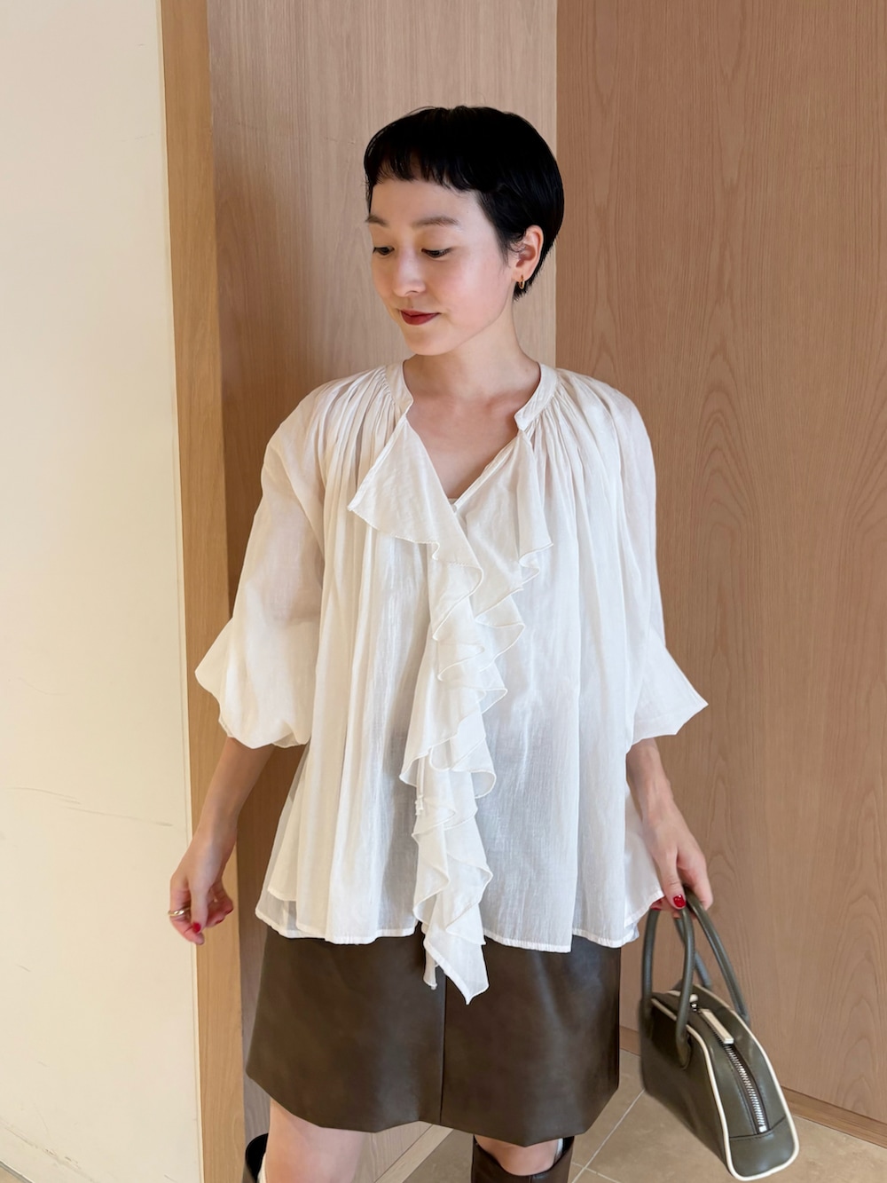 ホワイト系のシャツ/ブラウス、グレー系のテーラードジャケット、ブラウン系のスカートを着用したレディースの秋コーディネートの3枚目の写真