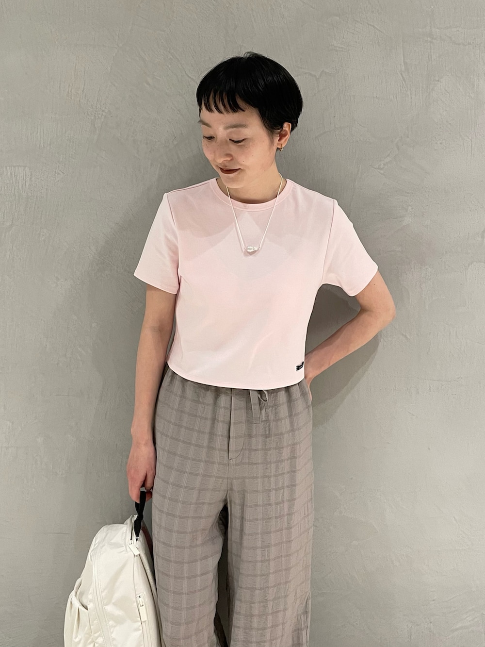 ピンク系のTシャツ/カットソー、グレー系のその他パンツ、ホワイト系のバックパック/リュックを着用したレディースの春コーディネートの4枚目の写真