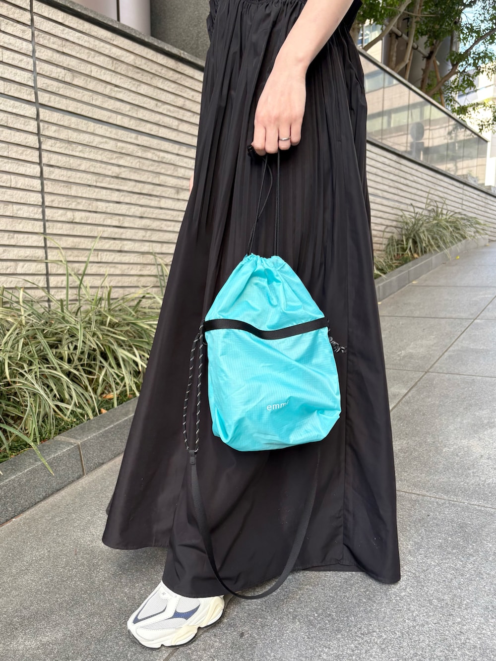 ブラック系のワンピース、ブルー系のショルダーバッグ、ブルー系のスニーカーを着用したレディースの夏コーディネートの4枚目の写真