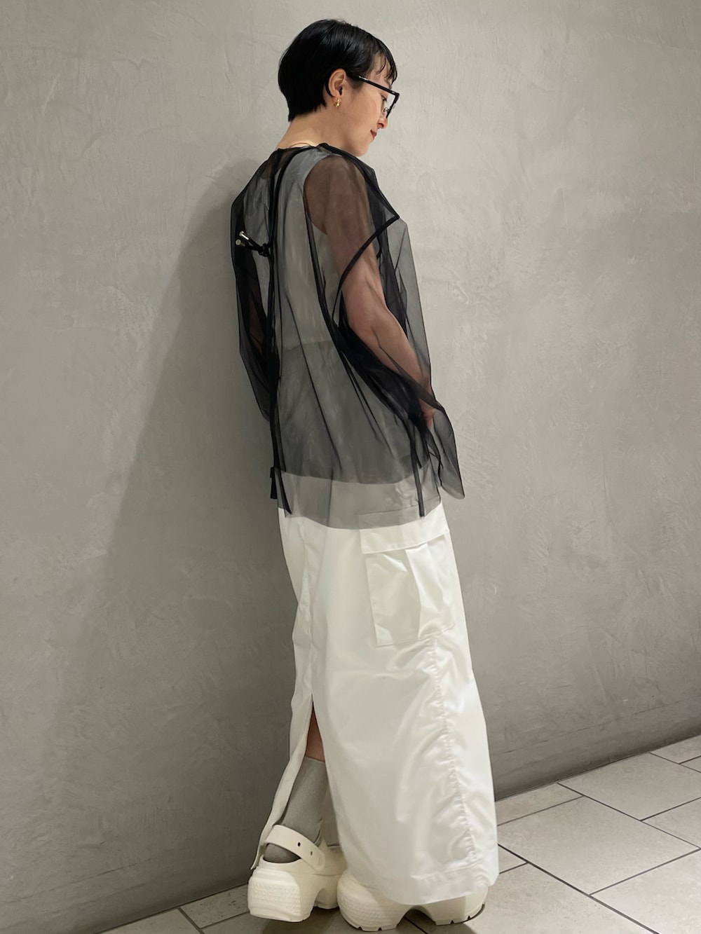 ホワイト系のタンクトップ、ブラック系のTシャツ/カットソー、ホワイト系のスカートを着用したレディースの冬コーディネートの3枚目の写真