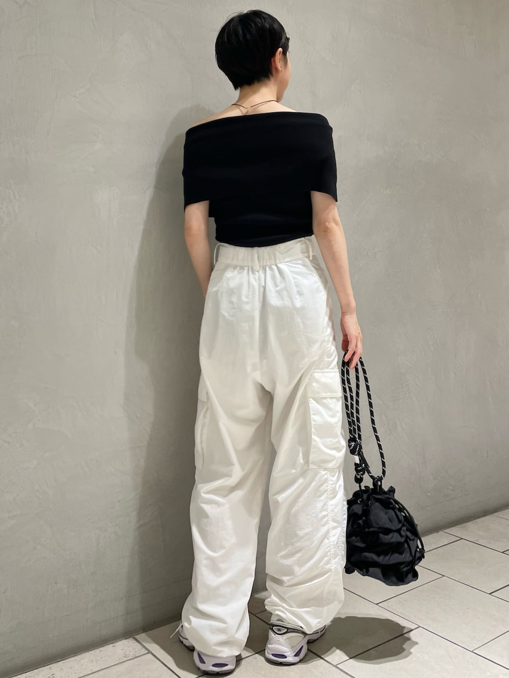 ブラック系のニット/セーター、ホワイト系のその他パンツ、ブラック系のショルダーバッグを着用したレディースの秋コーディネートの3枚目の写真