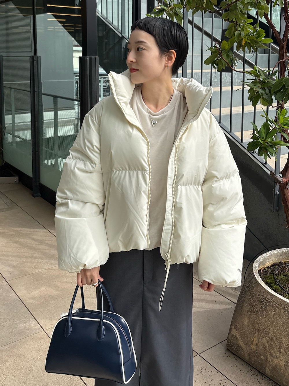 ホワイト系のダウンジャケット/コート、ホワイト系のTシャツ/カットソー、グレー系のスカートを着用したレディースの秋コーディネートの2枚目の写真