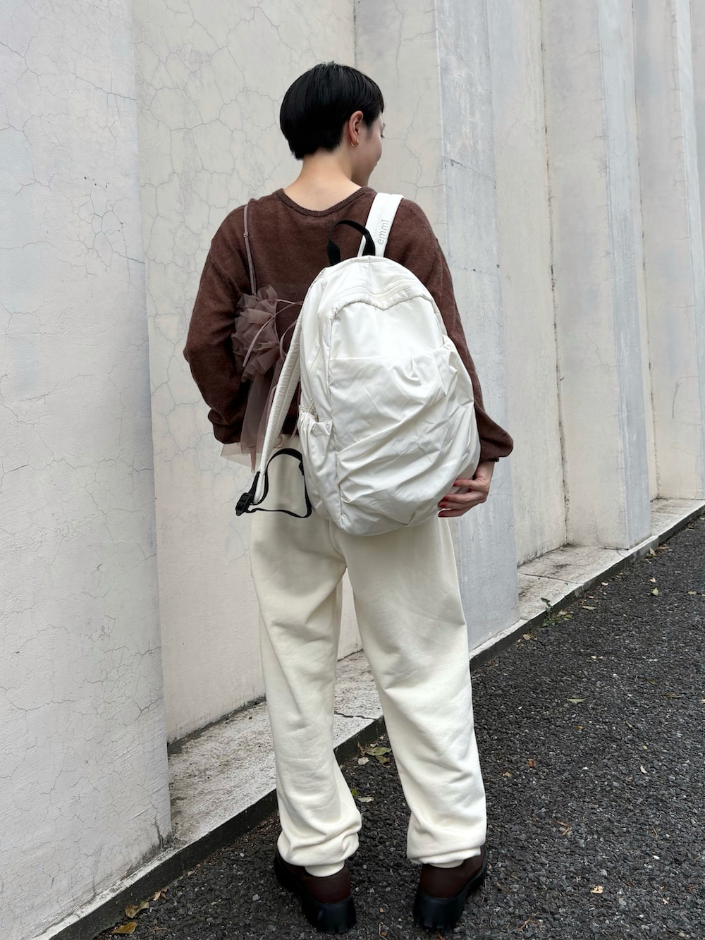 ブラウン系のニット/セーター、ブラウン系のTシャツ/カットソー、ホワイト系のスウェットパンツを着用したレディースの秋コーディネートの4枚目の写真