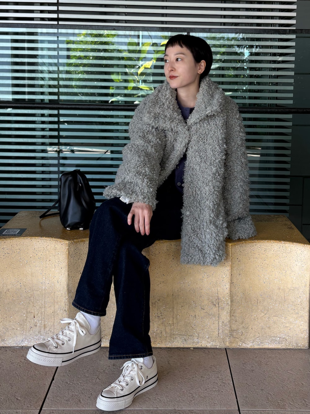 ホワイト系のスニーカー、ブルー系のカーディガン/ボレロ、グリーン系のピーコートを着用したレディースの冬コーディネートの3枚目の写真