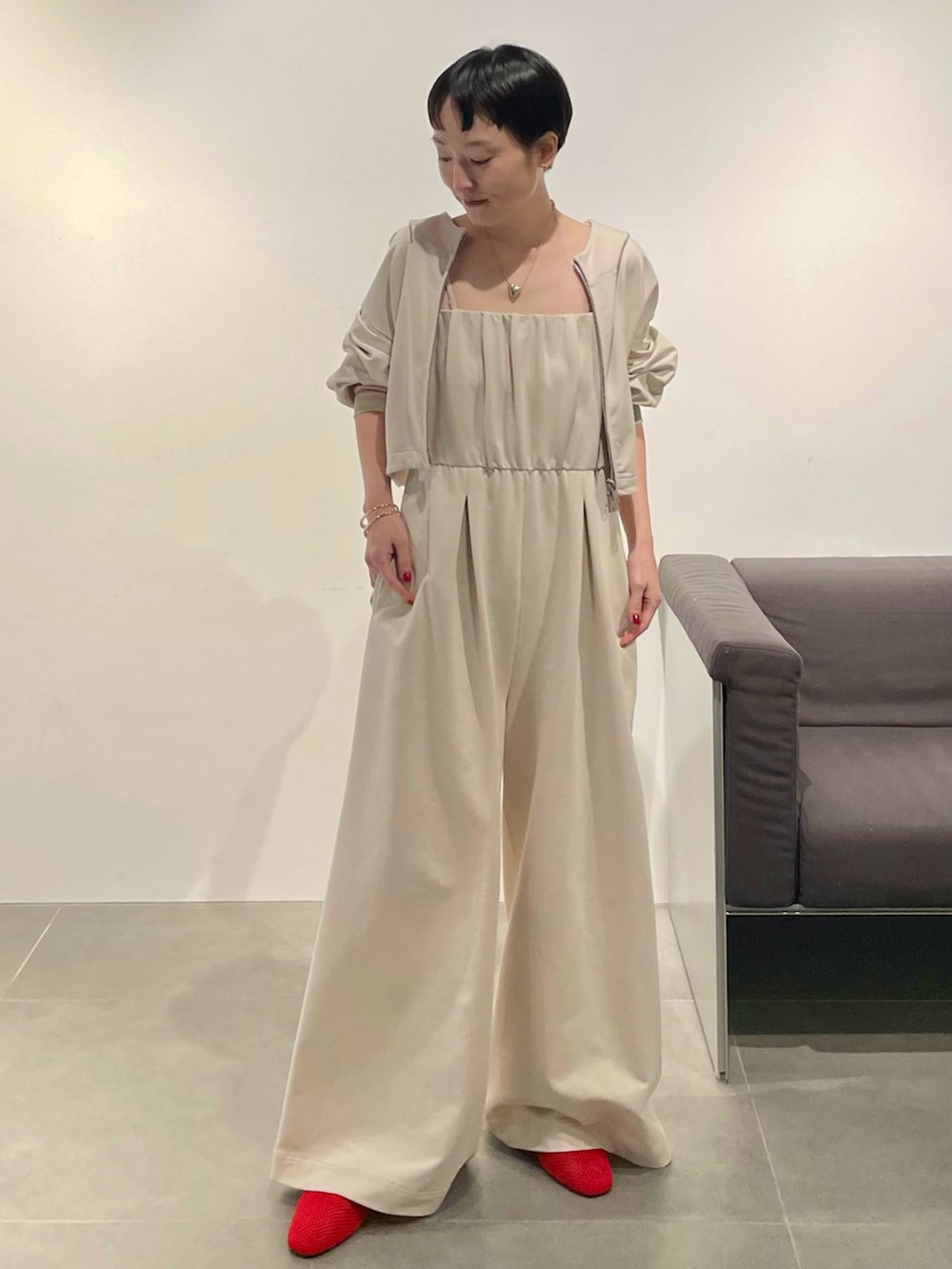 ベージュ系のつなぎ/オールインワン、レッド系のパンプス、ゴールド系のネックレスを着用したレディースの春コーディネートの2枚目の写真